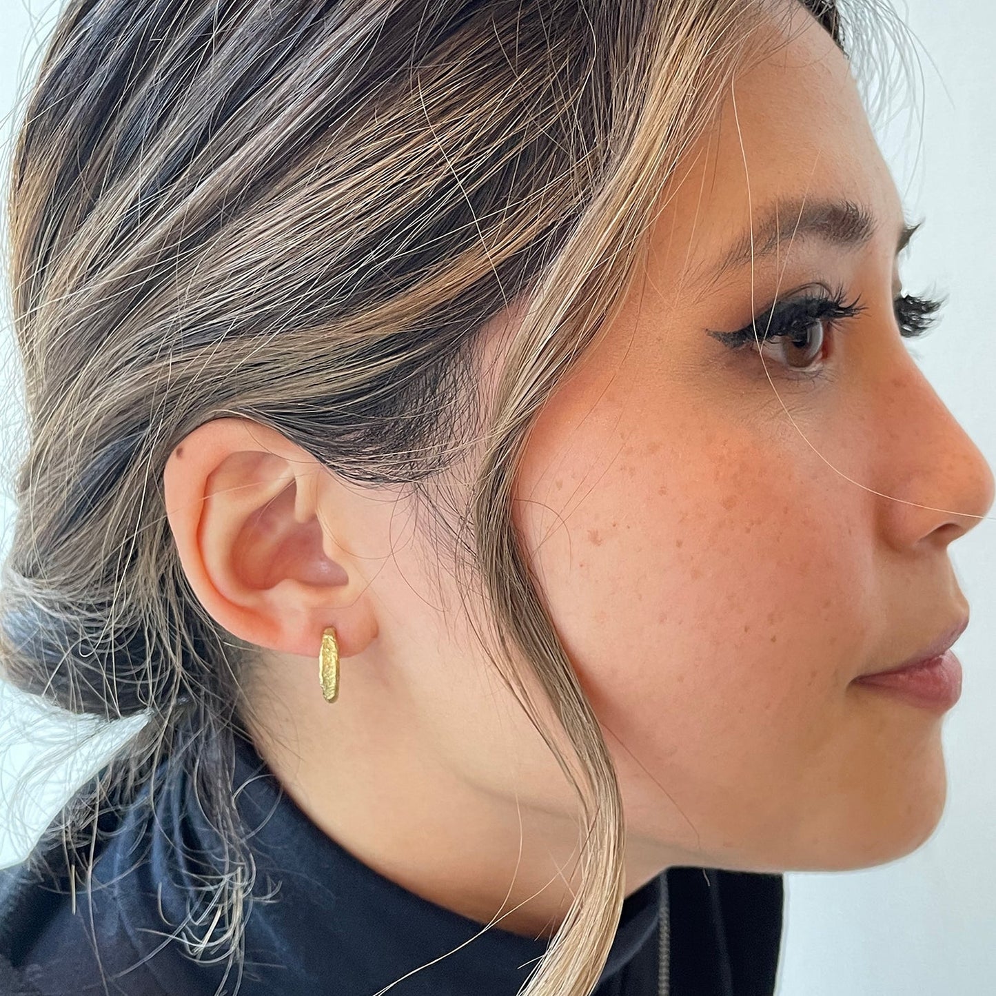 Side view of model wearing Jan Hoop in 18ky gold by Betsy Barron in right ear.