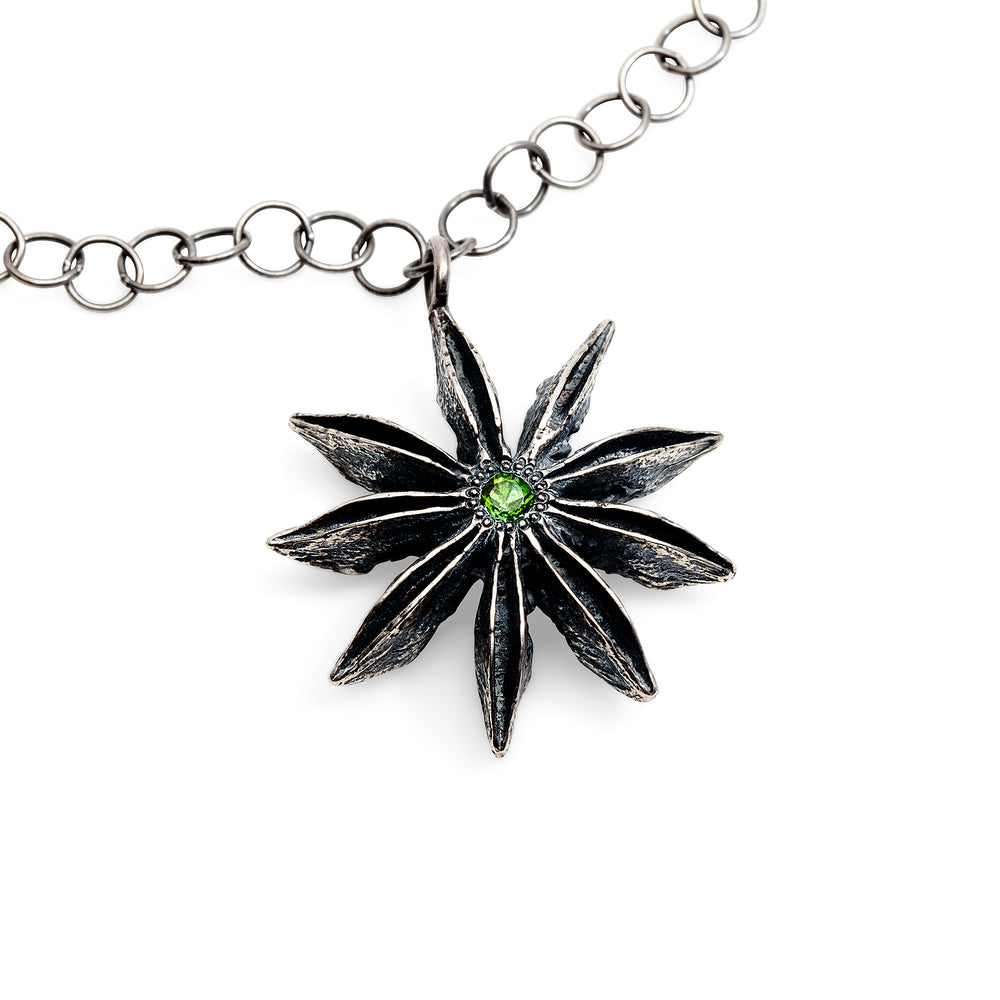 Detail view of sterling silver Star Anise Necklace with emerald