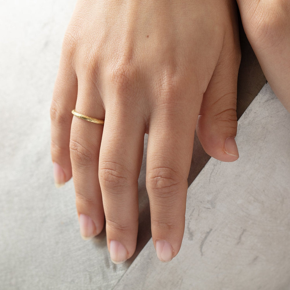 
                      
                        Lu Band in 18k yellow gold by Betsy Barron, worn on model's right hand.
                      
                    